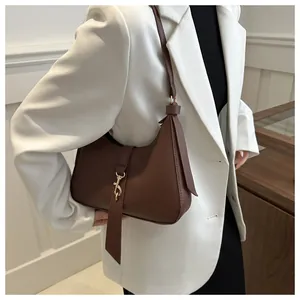 Detailansicht der braunen Hobo-Tasche mit Lychee-Leder und goldenem Metallverschluss