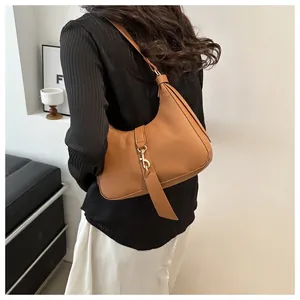 Detail einer braunen Hobo-Tasche aus Leder mit Lychee-Muster und Metallschnalle