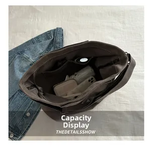 Detail showing high-capacity interior of dark brown canvas tote bag with multiple pockets