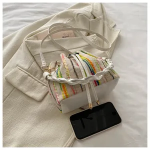 Detailed view of woven bucket bag texture with colorful vertical stripes and phone inside