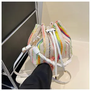 Detail of colorful vertical stripes and drawstring closure on a beige bucket bag