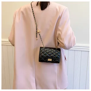 Detail of black quilted leather crossbody bag with gold chain strap and twist lock