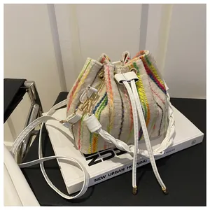 Detail of colorful woven stripes and white drawstring closure on a trendy bucket bag