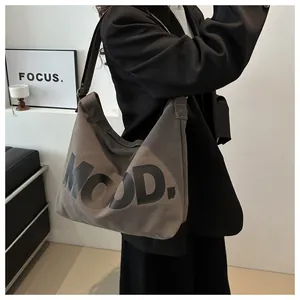 Detail showing high-capacity dark grey canvas crossbody bag with white MOOD text print