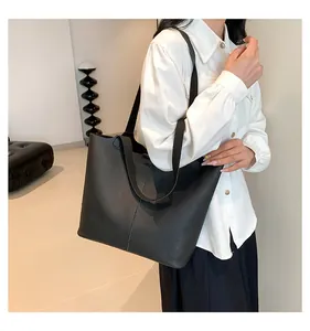 Close-up of black large-capacity tote bag in textured lychee leather with vertical stitching