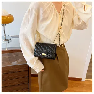 Close-up of black quilted leather crossbody bag with gold-tone twist lock and chain strap