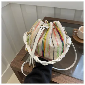 Detail of colorful vertical striped bucket bag with woven texture and white drawstring