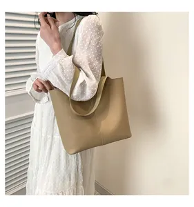 Detail of khaki leather tote bag with lychee texture and wide strap for daily commute
