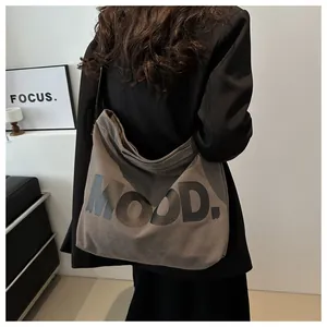 Detail of large dark brown canvas tote bag with MOOD lettering and thick texture