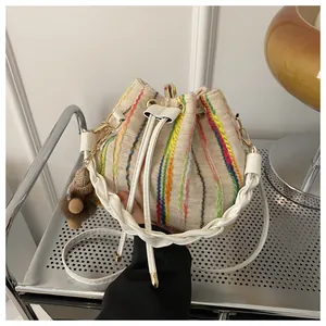 Detailed view of woven bucket bag with colorful vertical stripes and drawstring closure