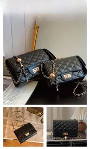 Detail of black quilted chain bag featuring gold ball adjuster and twist lock closure