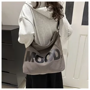 Detailed view of gray canvas crossbody bag with black MOOD print on wide shoulder strap