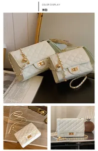 Detail of off-white quilted chain bag with gold metal ball clasp in lifestyle setting