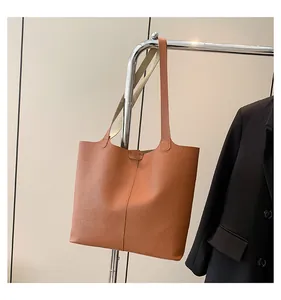 Detailed view of caramel leather tote bag with pebble texture and slim shoulder straps