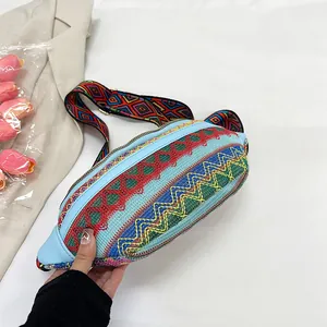 Detail view of ethnic embroidered crossbody bag with colorful woven pattern and wide strap