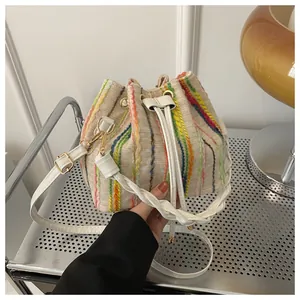 Detail of woven bucket bag featuring vibrant vertical stripes and drawstring closure