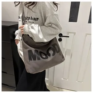 Detail showing charcoal grey canvas bag with bold MOOD lettering and crossbody strap
