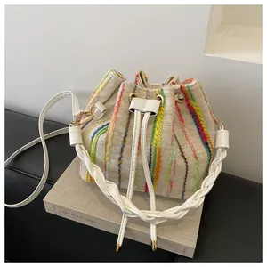 Close-up of woven bucket bag with vertical colorful stripes and drawstring closure