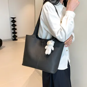 Classic black large-capacity tote bag in lychee leather with a white plush bear charm