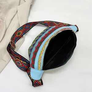 Detail of colorful geometric ethnic chest bag with sky blue leather and zipper closure