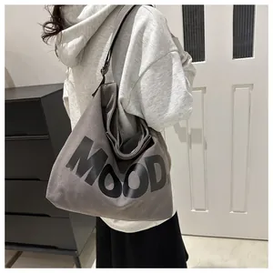 Macro view of grey canvas hobo bag featuring MOOD lettering and adjustable strap