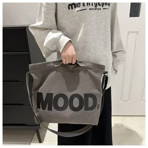 Detailed shot of gray canvas tote bag featuring black MOOD print and adjustable strap