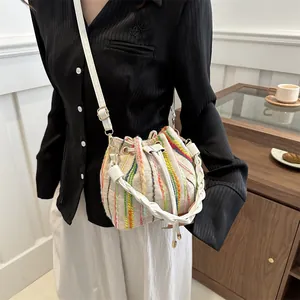 Chic cream bucket bag with vertical colorful stripes and woven top handle for women