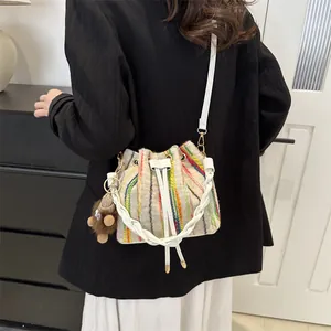 Colorful striped woven bucket bag with white handles and a cute plush animal charm