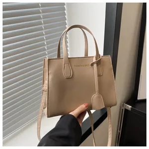 Detailed view of beige PU leather handbag with gold Fashion & Bags logo and sturdy handles