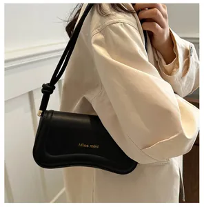 Detail showing wave-shaped base and Miss mini gold lettering on black shoulder bag