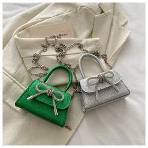 Détail de mini sacs à main pailletés avec nœuds en strass et chaîne argentée
