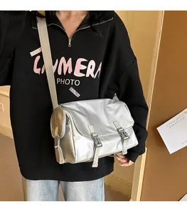 Sac messager métallisé argenté avec doubles boucles et large bandoulière réglable en détail