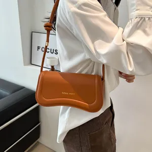 Brown leather French baguette shoulder bag with wavy base and knotted strap detail