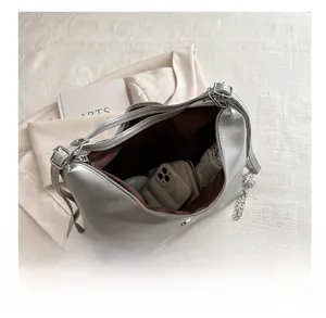 Vue intérieure du sac hobo argenté avec téléphone, portefeuille et parapluie