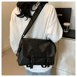 Vue arrière d'un mannequin portant un grand sac messager noir en nylon à deux boucles