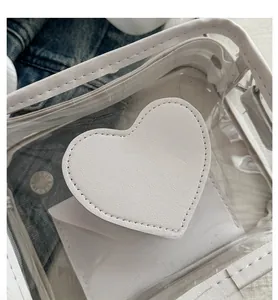 Dettaglio della borsa in PVC trasparente con cuore bianco e pochette interna coordinata