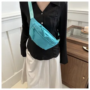 Lake blue nylon chest bag for women showing crossbody wear effect and dual zippers