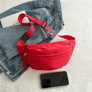 Bright red nylon crossbody chest bag with adjustable strap on denim jacket outfit