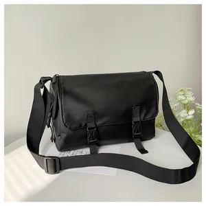 Détail de la besace noire en nylon avec deux boucles et une large bandoulière réglable