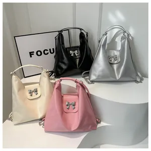 Vue détaillée de quatre sacs à nœuds en cuir noir argent crème et rose avec chaînes
