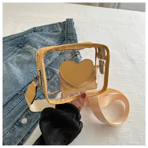 Dettaglio borsa a tracolla gialla in PVC con tasca a cuore e ampia tracolla in tessuto