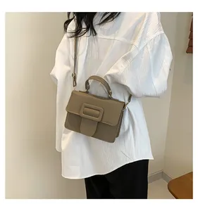 Petit sac carré marron kaki avec texture litchi et boucle porté par un mannequin