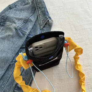 Contrast corduroy mini phone bag with yellow pleated strap and blue snap closure