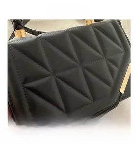 Détails macro d'un sac à main noir matelassé avec des fermoirs métalliques dorés