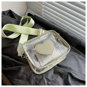 Dettaglio borsa a tracolla in PVC trasparente con patch a cuore verde salvia e tracolla