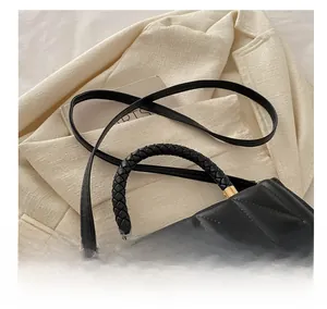 Détail de la poignée tissée et du cuir matelassé de ce petit sac à bandoulière noir chic