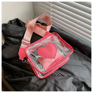 Dettaglio borsa a tracolla in PVC trasparente con toppa a cuore rosa e ampia tracolla