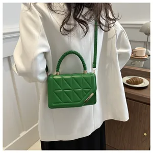 Détail du sac matelassé vert émeraude avec poignée tressée et finitions dorées chic