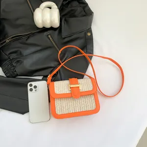 Sac bandoulière carré orange et paille avec sangle fine sur fond blanc minimaliste