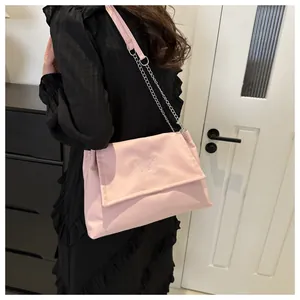 Détail du sac à bandoulière rose avec broderie papillon et bandoulière en chaîne argentée